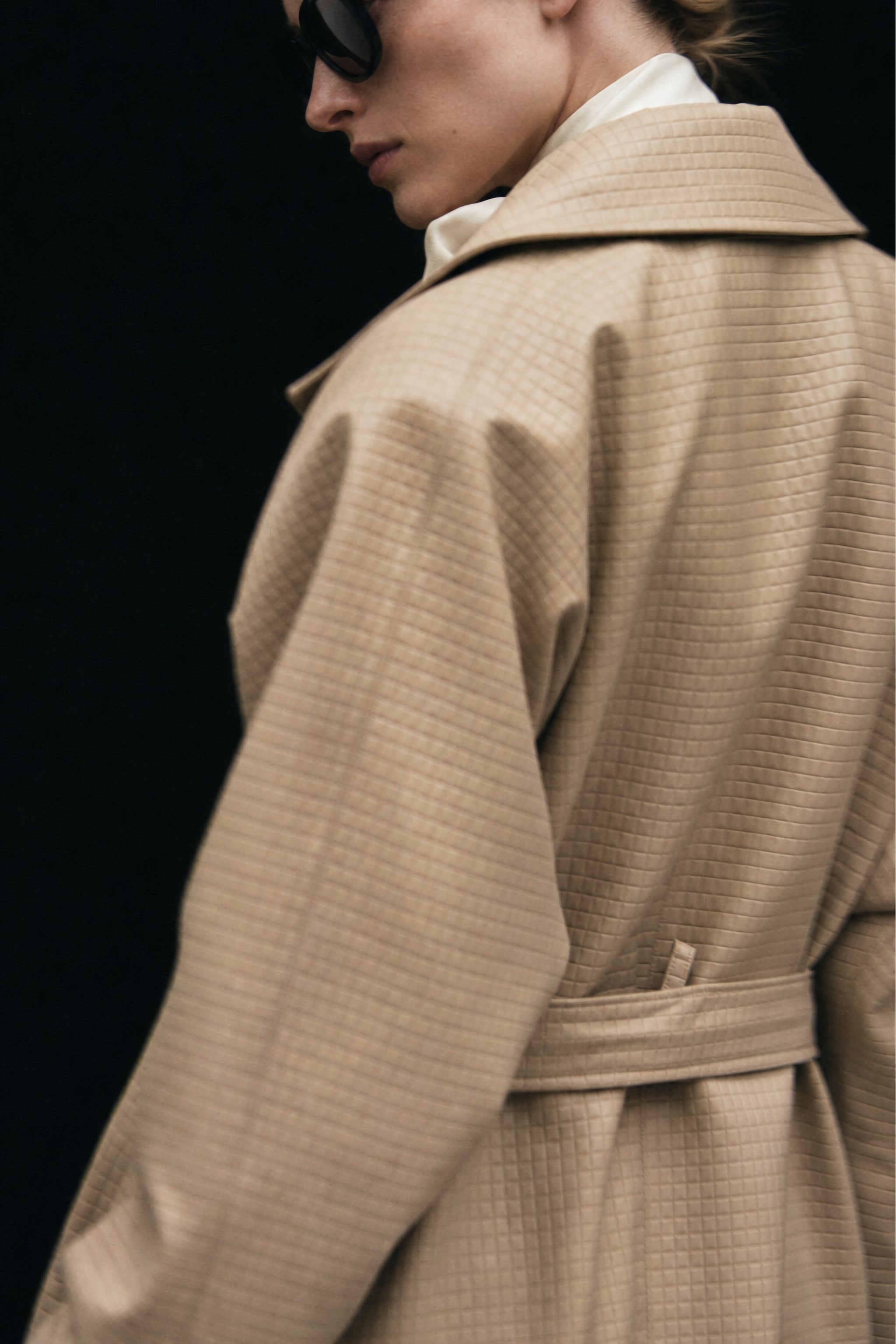 Embossed check faux leather trench coat in beige editorial image 3
